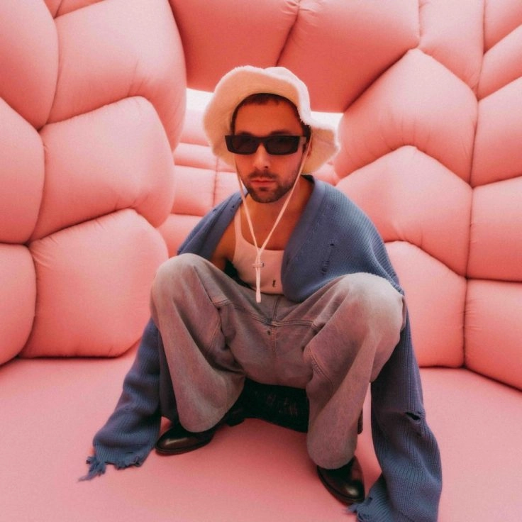 Andres Reisinger seated in pink padded room installation at museum Amsterdam.